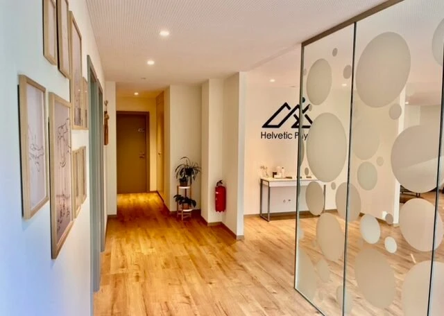 Photo du centre de physiotherapie helvetic physio geneve couloir avec cadre et porte en verre