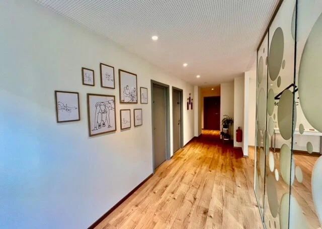 photo entree centre helvetic physio avec cadres de physiotherapie et parquet bois